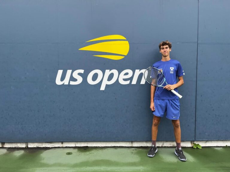 Tymon Litwic z rakietą przy ścianie z logo US Open