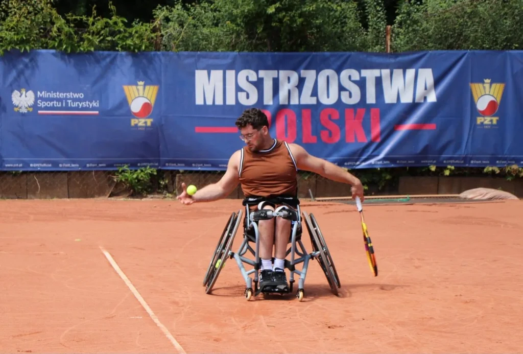 Zawodnik na wózku przy banerze Mistrzostw Polski