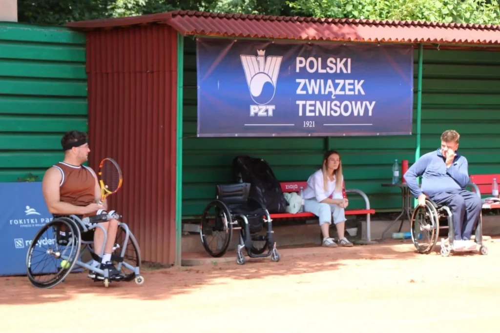 Zawodnicy odpoczywają w wiacie przy korcie